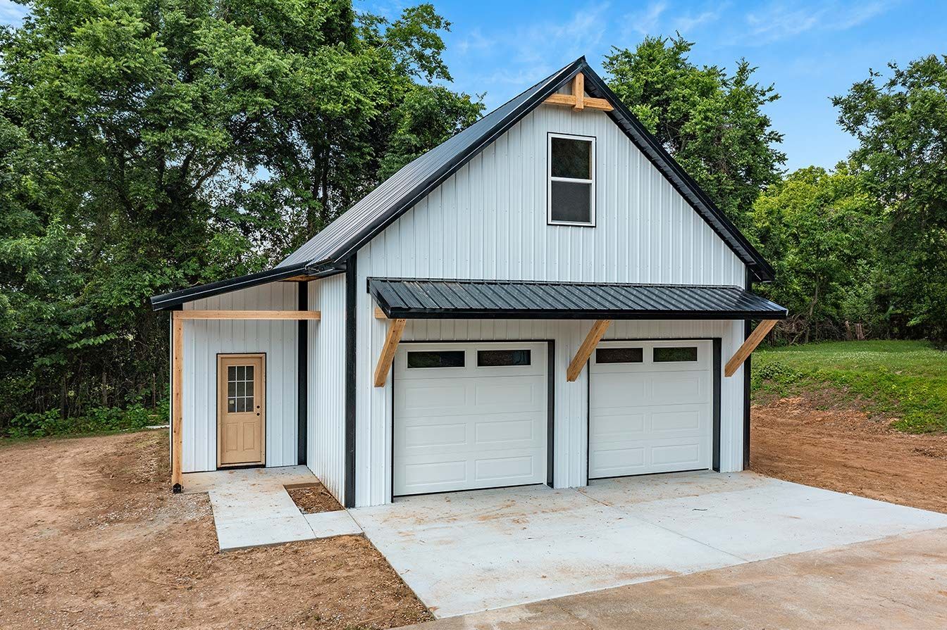 A white garage with two garage doors and a black roof.
