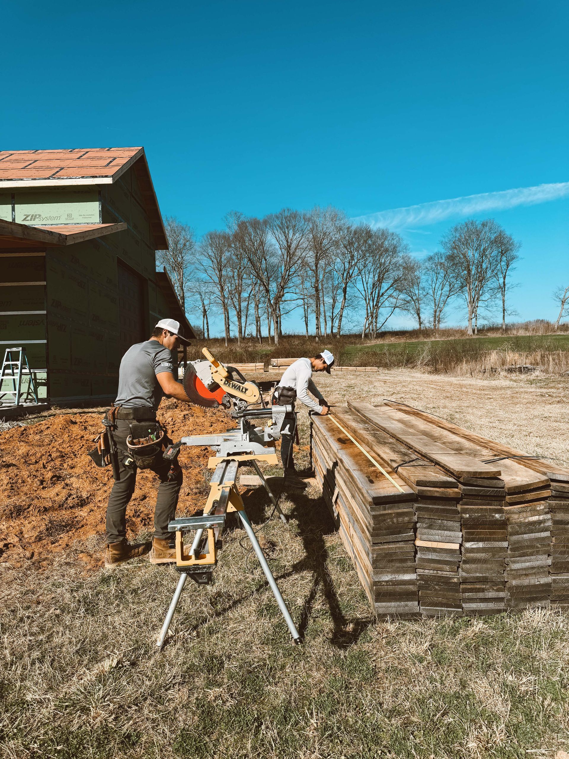 A group of construction workers are working on a building in a field.