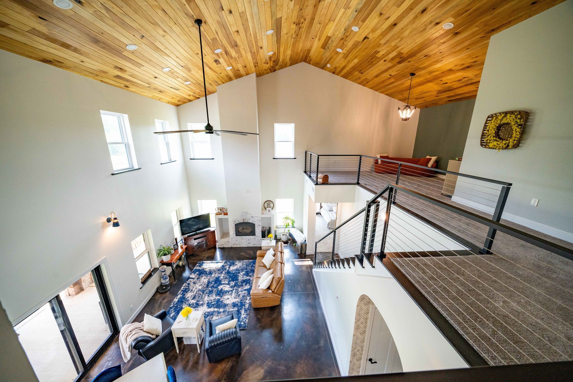 An aerial view of a living room with a wooden ceiling and stairs.