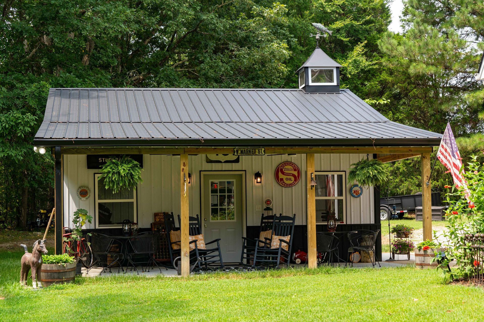 A small white house with a black roof and a porch.