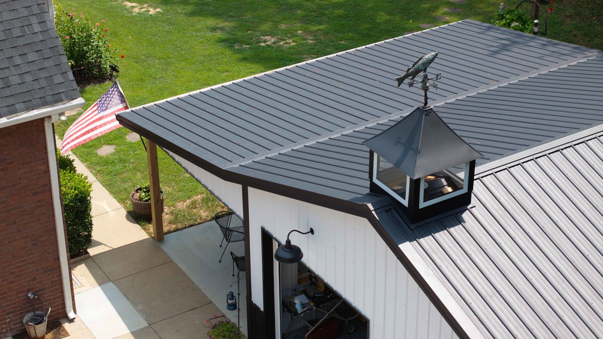An aerial view of a white house with a black roof.