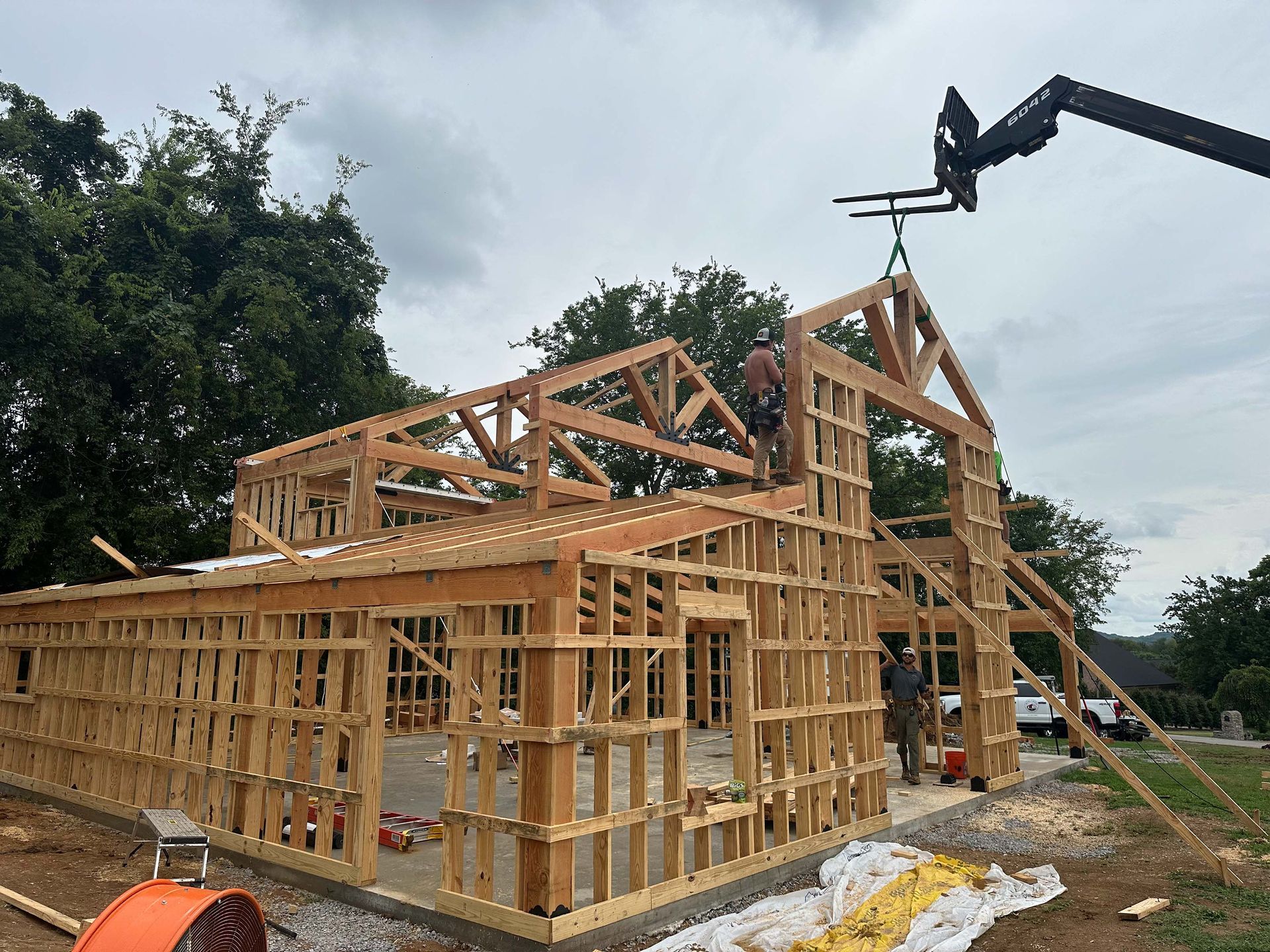 A large wooden structure is being built with a crane.