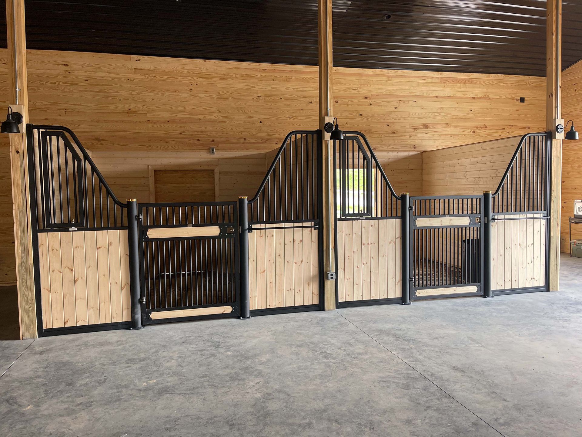 A row of wooden horse stalls in a barn