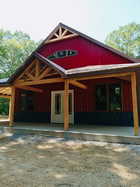 A red house with a porch and a wooden roof