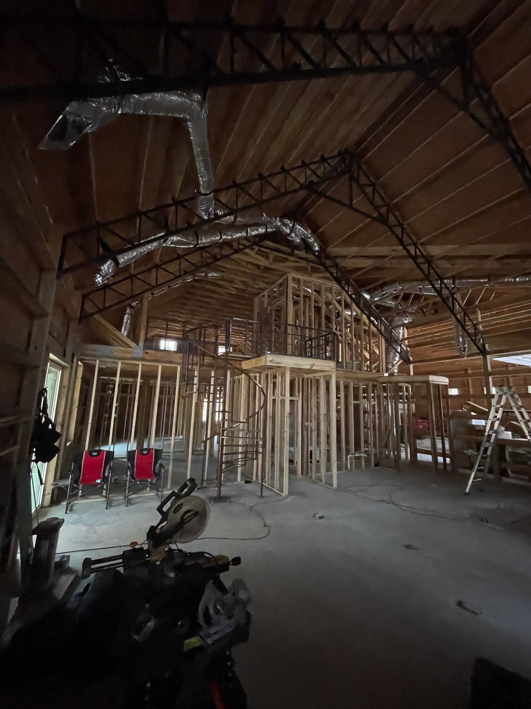 A motorcycle is parked inside of a building under construction.