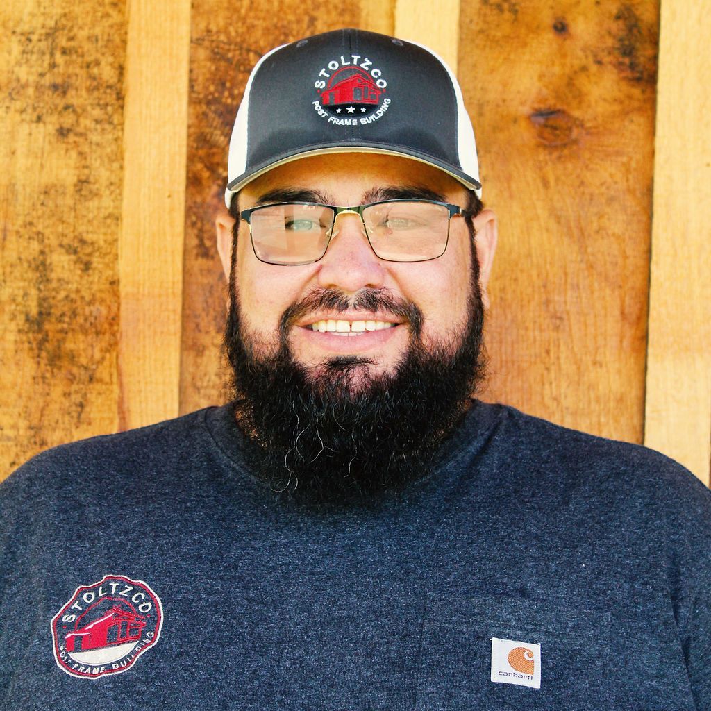 A man with a beard is wearing a hat and glasses.