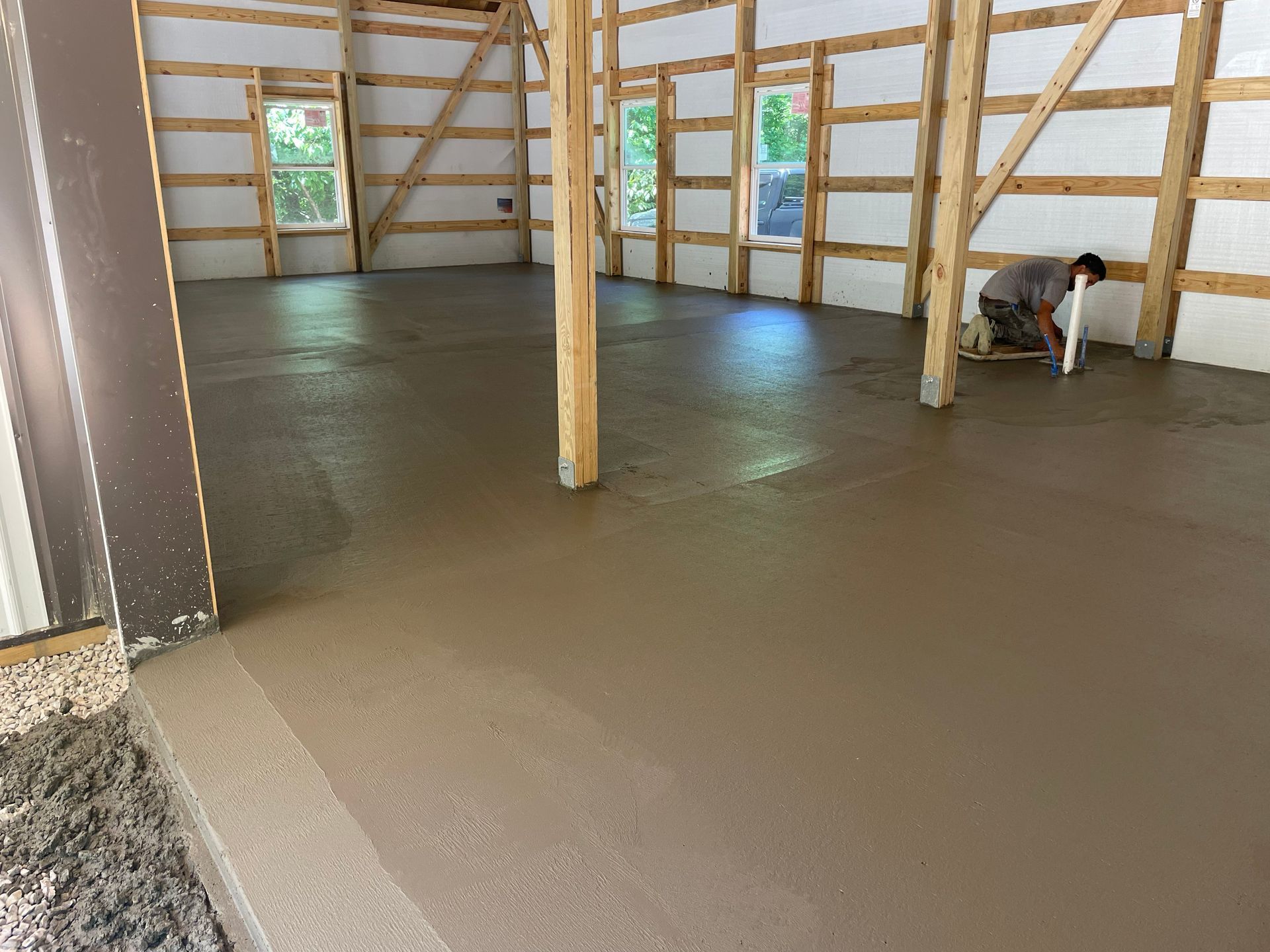 A man is working on a concrete floor in a building.