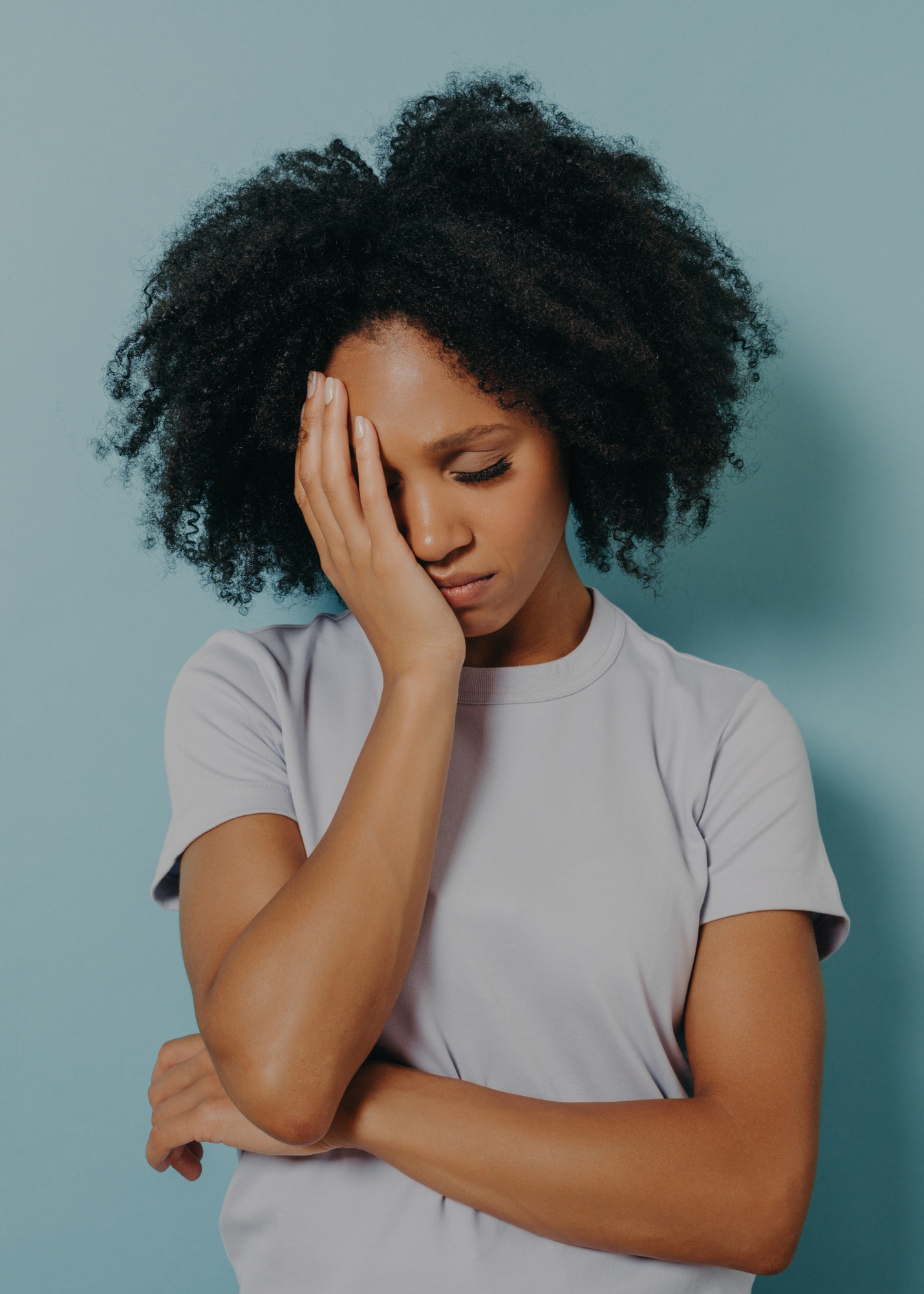 woman who is looking down with her head in her hand