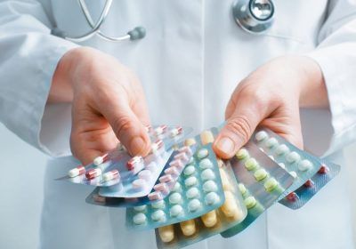 doctor holding several antibiotic pill packs