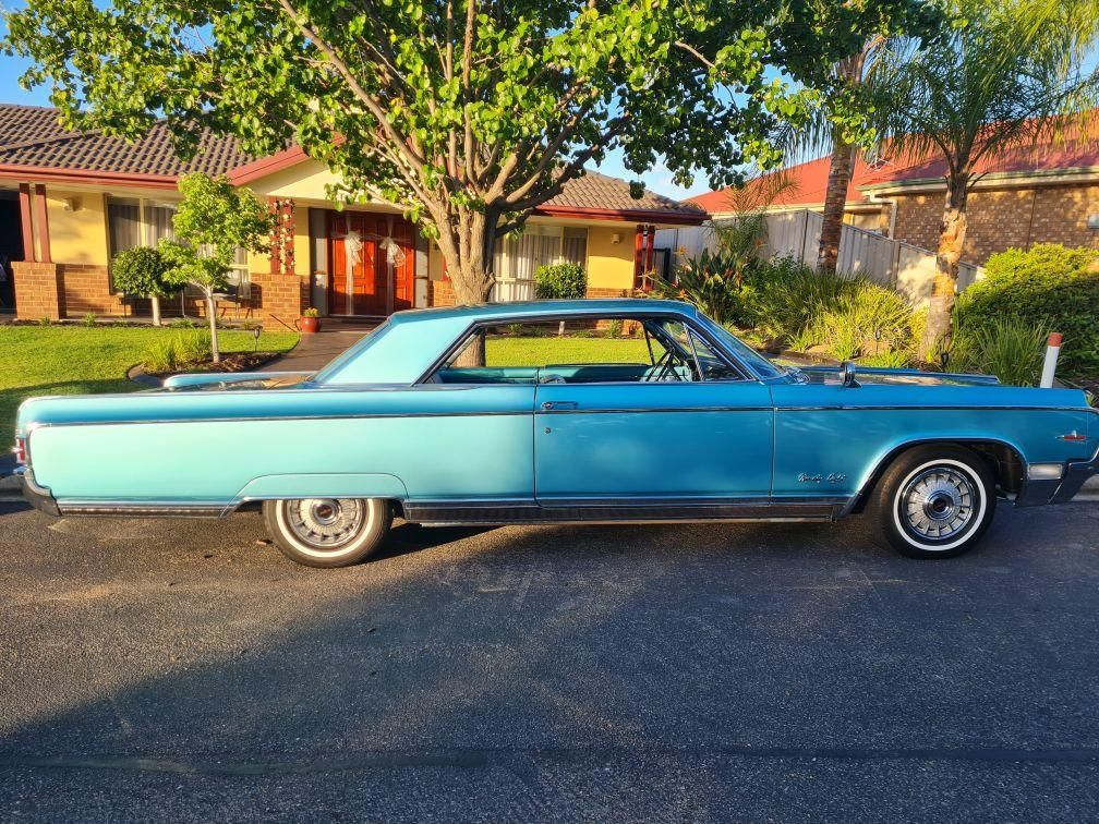 A blue car is parked in front of a house