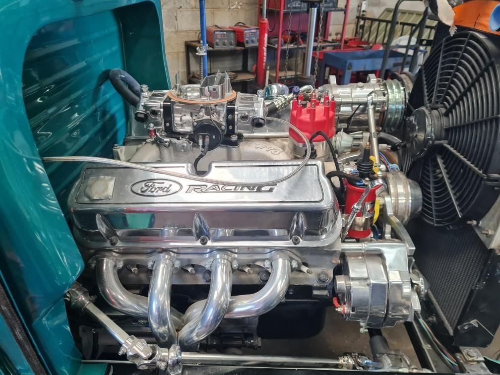 A ford engine with a fan attached to it