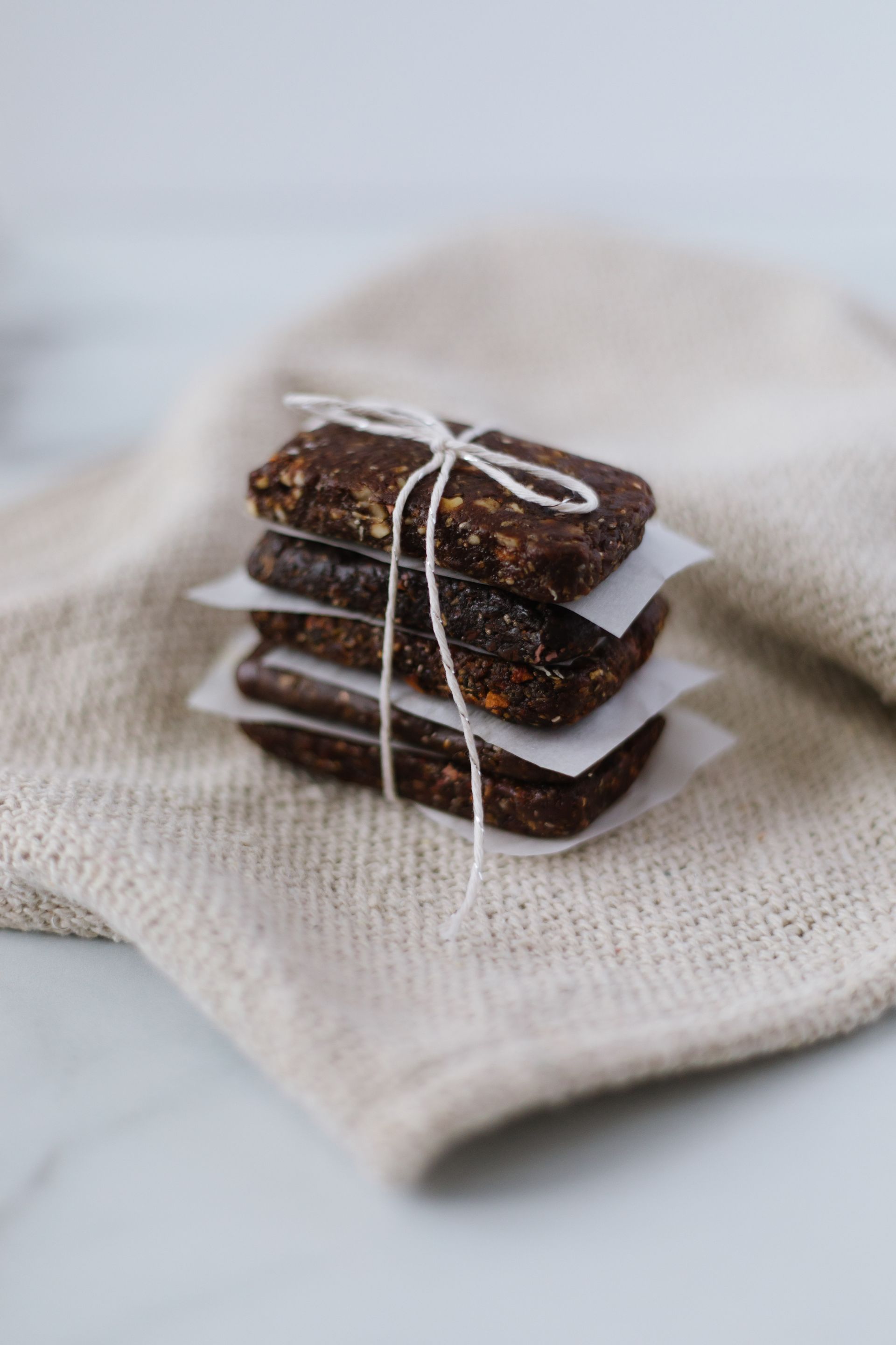 a stack of chocolate bars tied with string on a napkin .