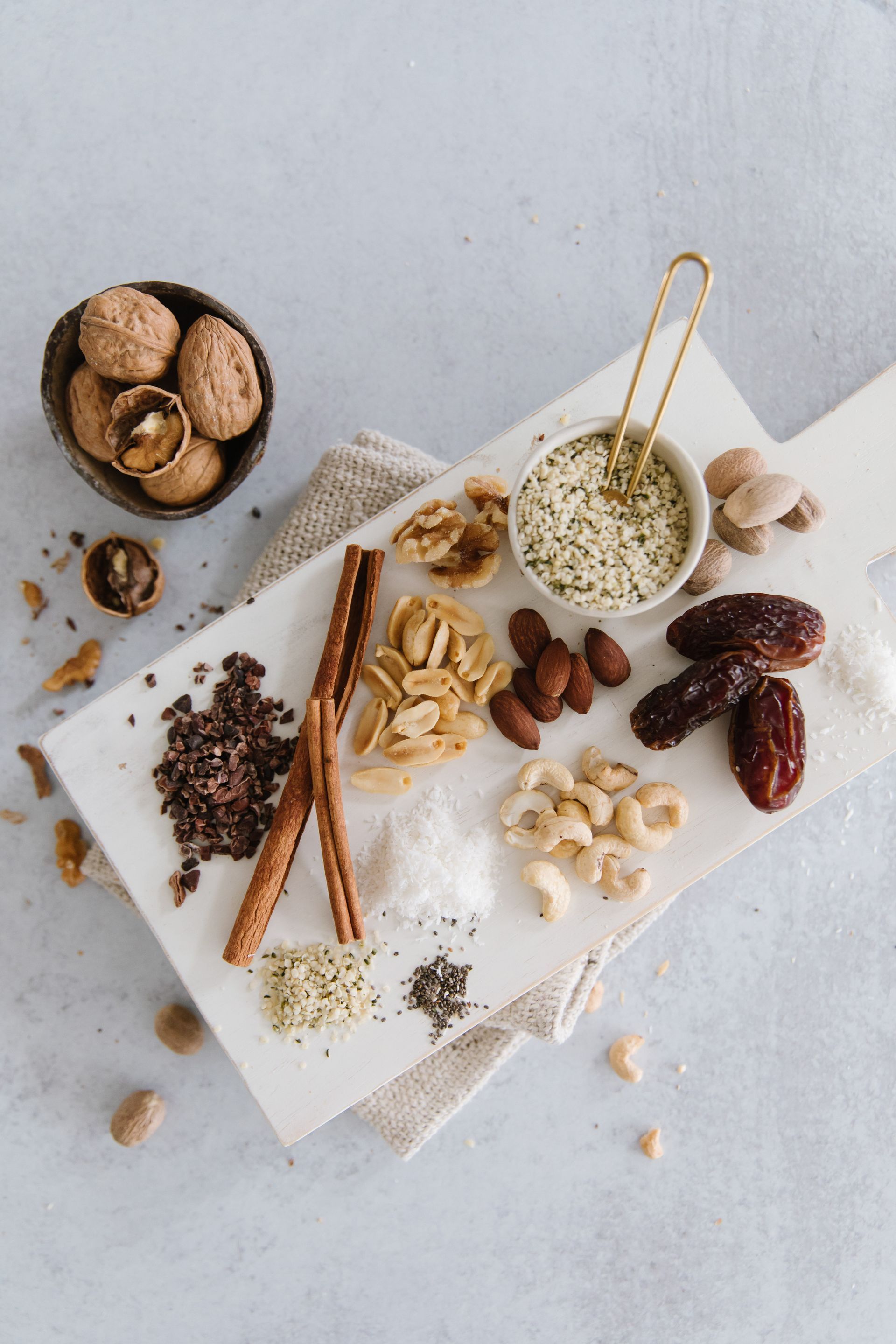 there are many different types of nuts and spices on the cutting board .