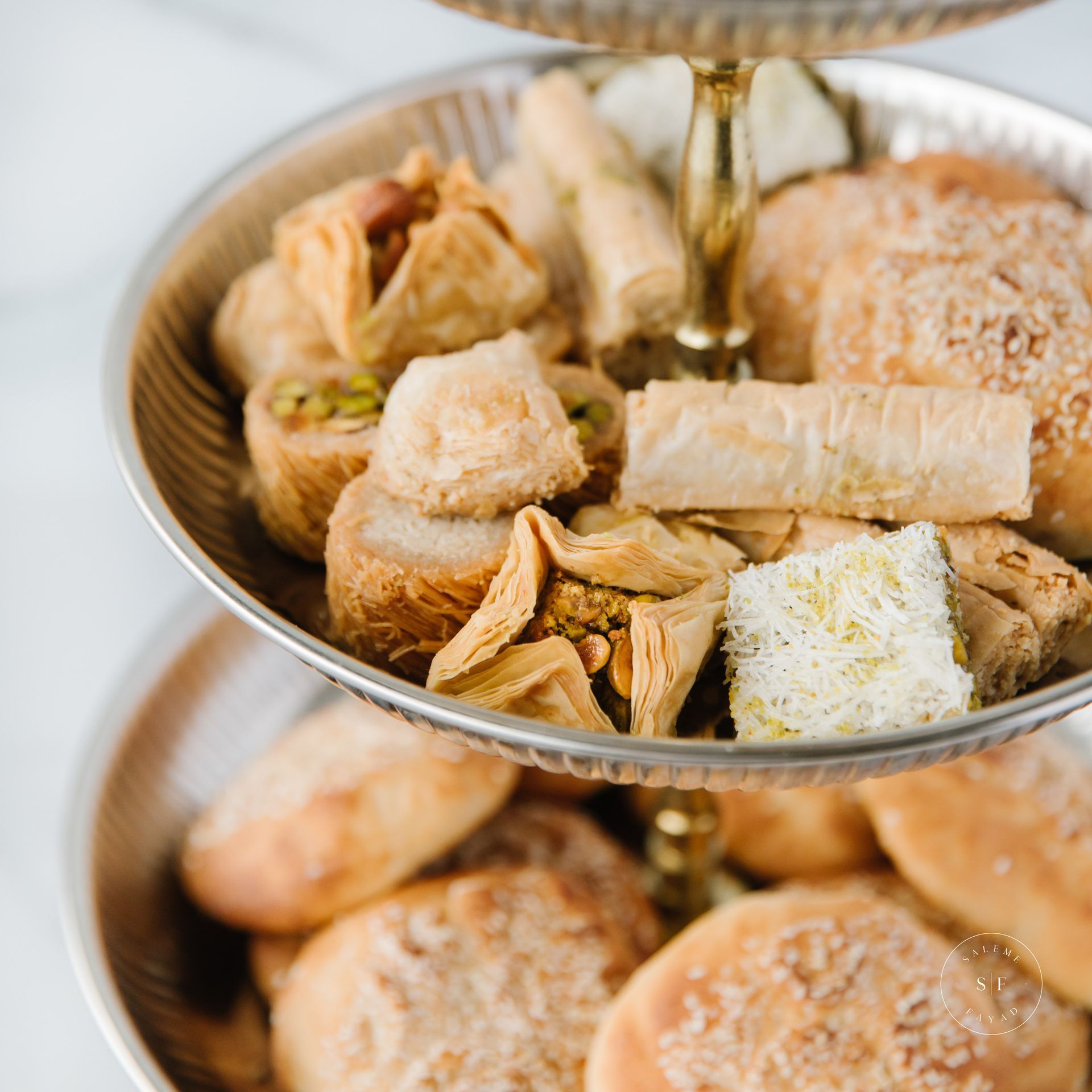 a three tiered tray filled with bread and pastries on a table .