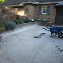 A sandy backyard with a brick wall and a wheelbarrow. A sandy backyard with a brick wall and a wheelbarrow.
