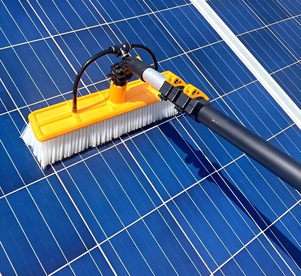 A Yellow And Black Brush Is Cleaning A Solar Panel — Out On A Limb Tree and Garden Care In Broulee, NSW