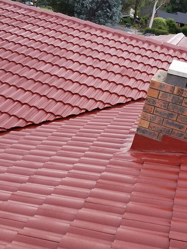 A New Red Tiled Roof With A Chimney On Top Of It — ACT Roofing in Ngunnawal, ACT