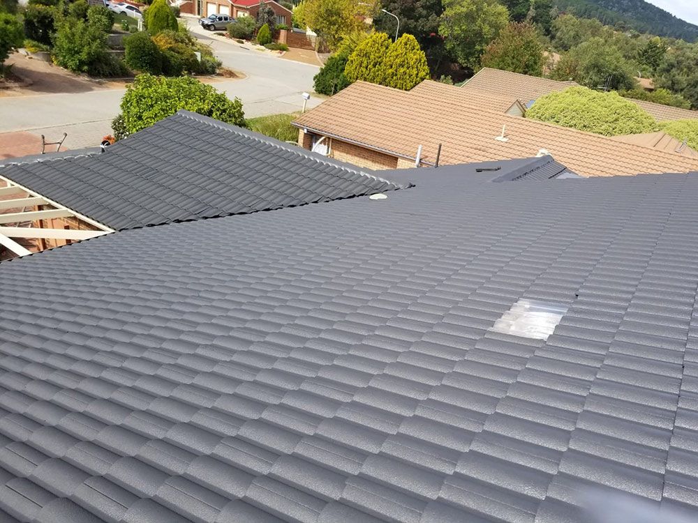 The Roof Of A House With A Grey Tile Roof Is Being Built — ACT Roofing in Ngunnawal, ACT