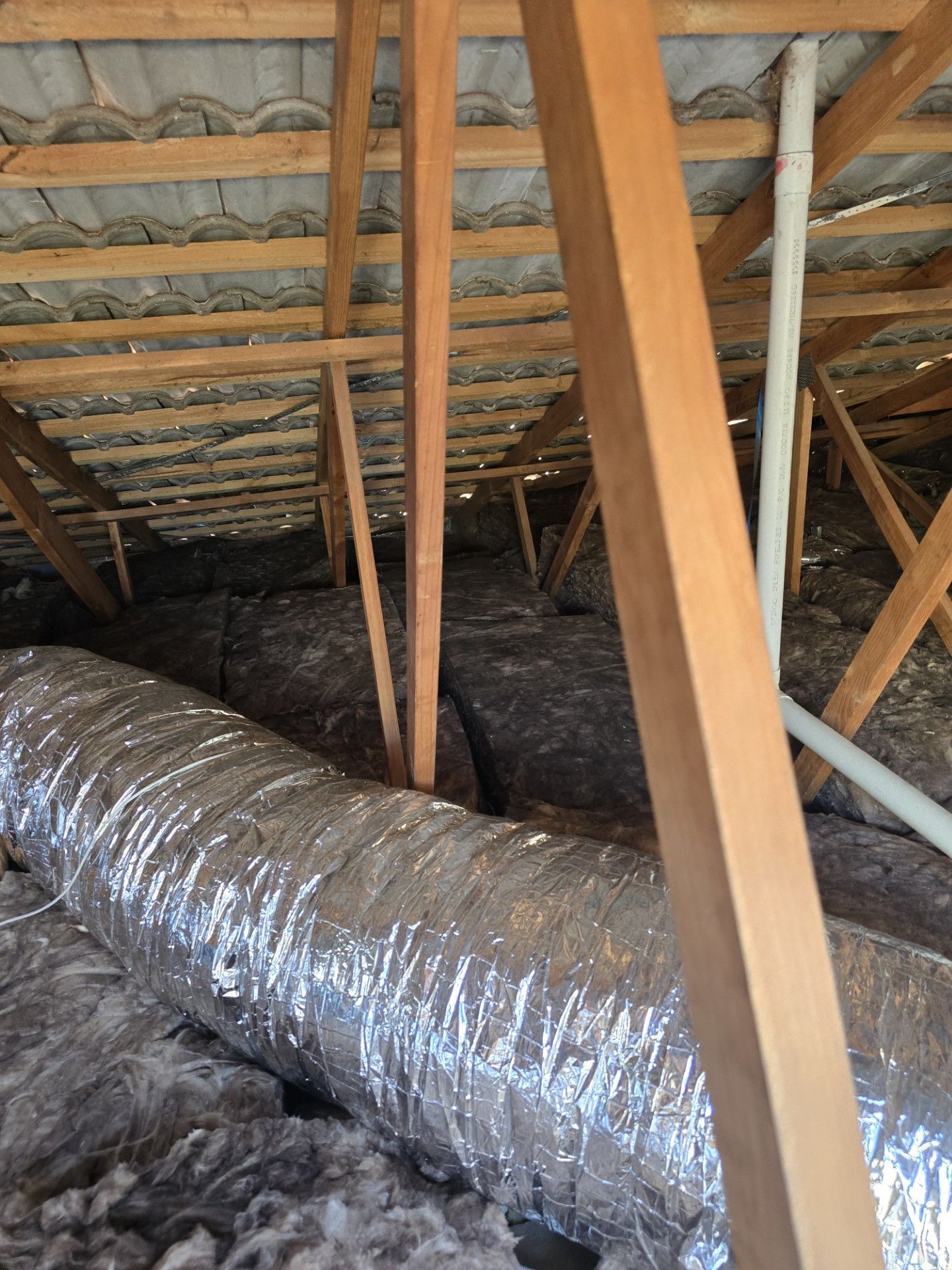 A Brown Tiled Roof With A Chimney In The Background — ACT Roofing in Ngunnawal, ACT