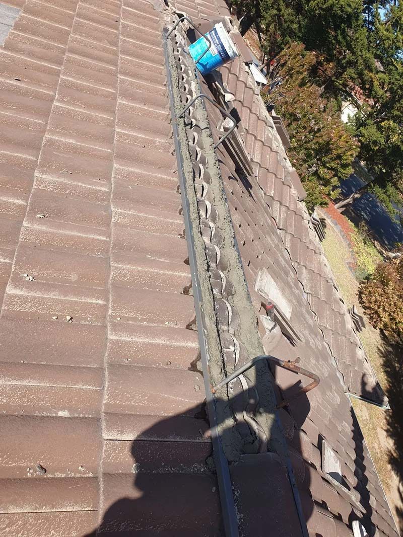 A Person Is Standing On The Roof For Construction — ACT Roofing in Queanbeyan, NSW