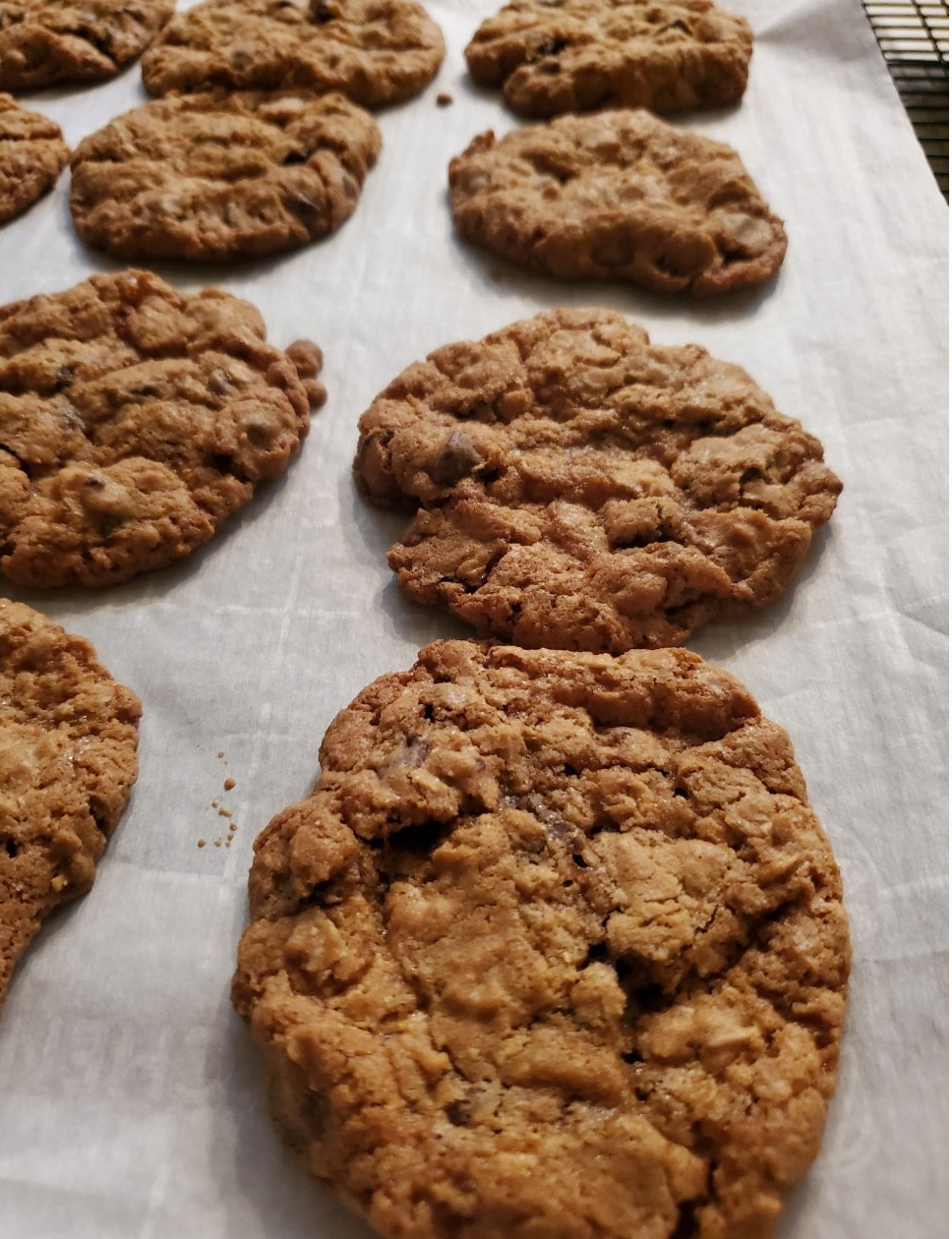 A bunch of cookies are sitting on a piece of wax paper