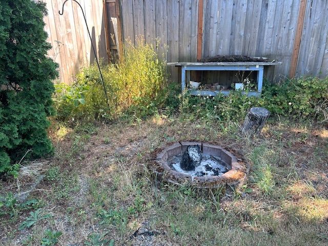 There is a fire pit in the middle of the yard.