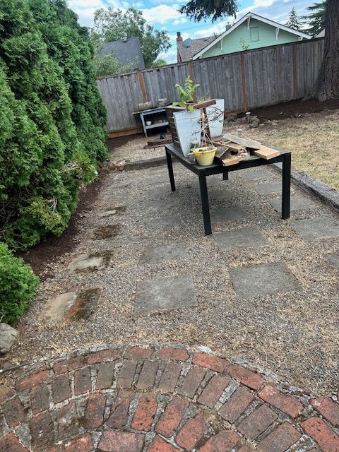 There is a table with potted plants on it in the backyard.