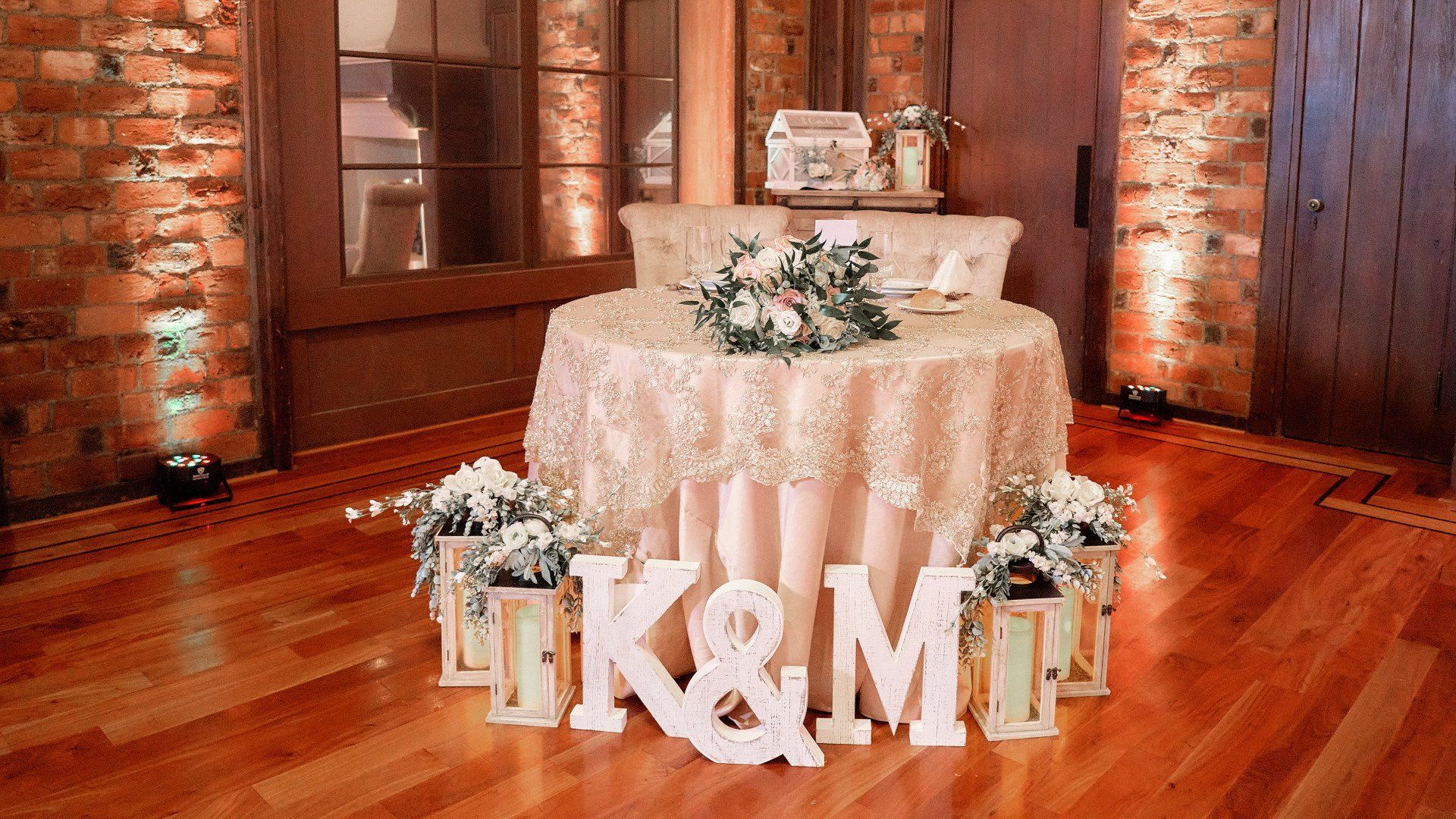 A wedding reception with a table and chairs and a sign that says `` gk & m ''.