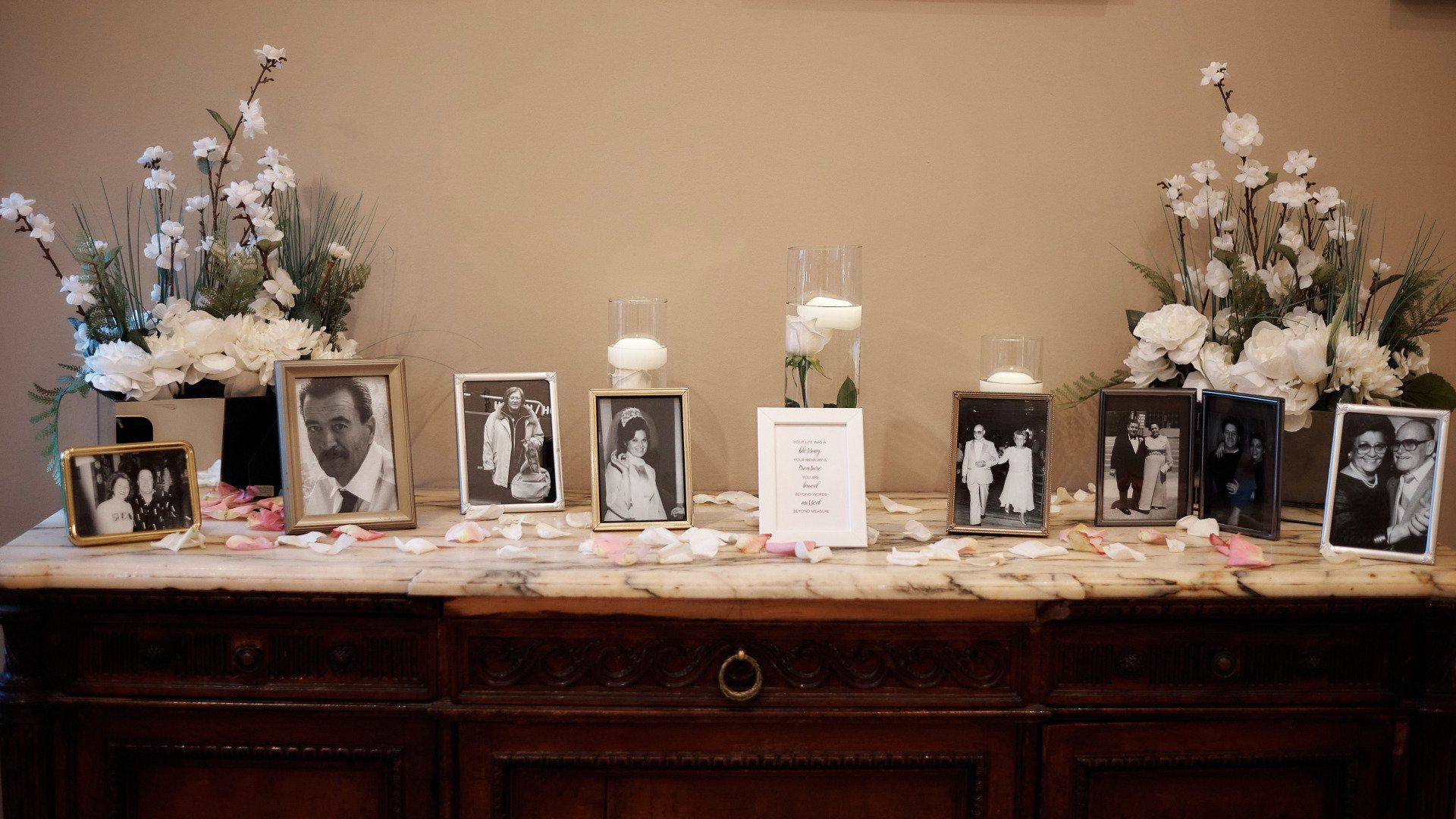 A table with a bunch of pictures and flowers on it