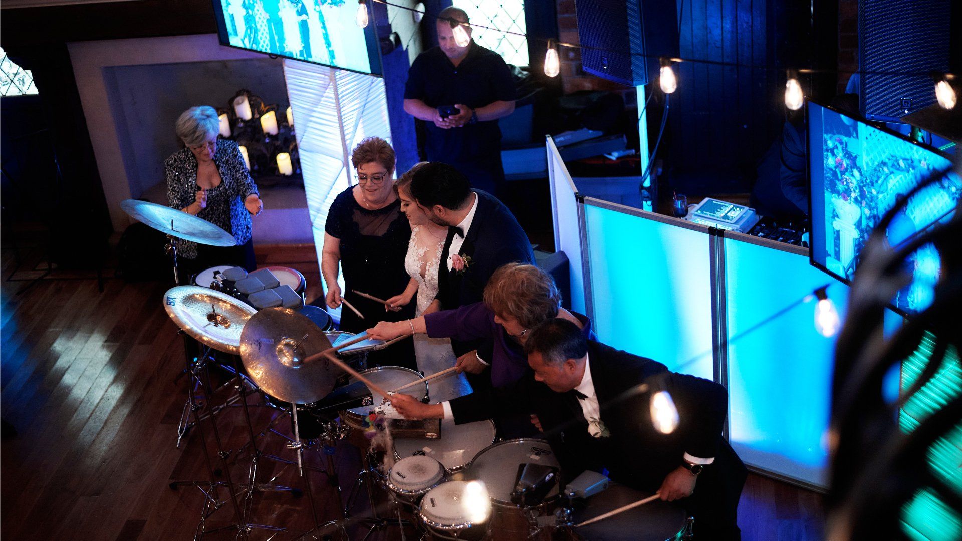 A group of people are playing drums in a room.