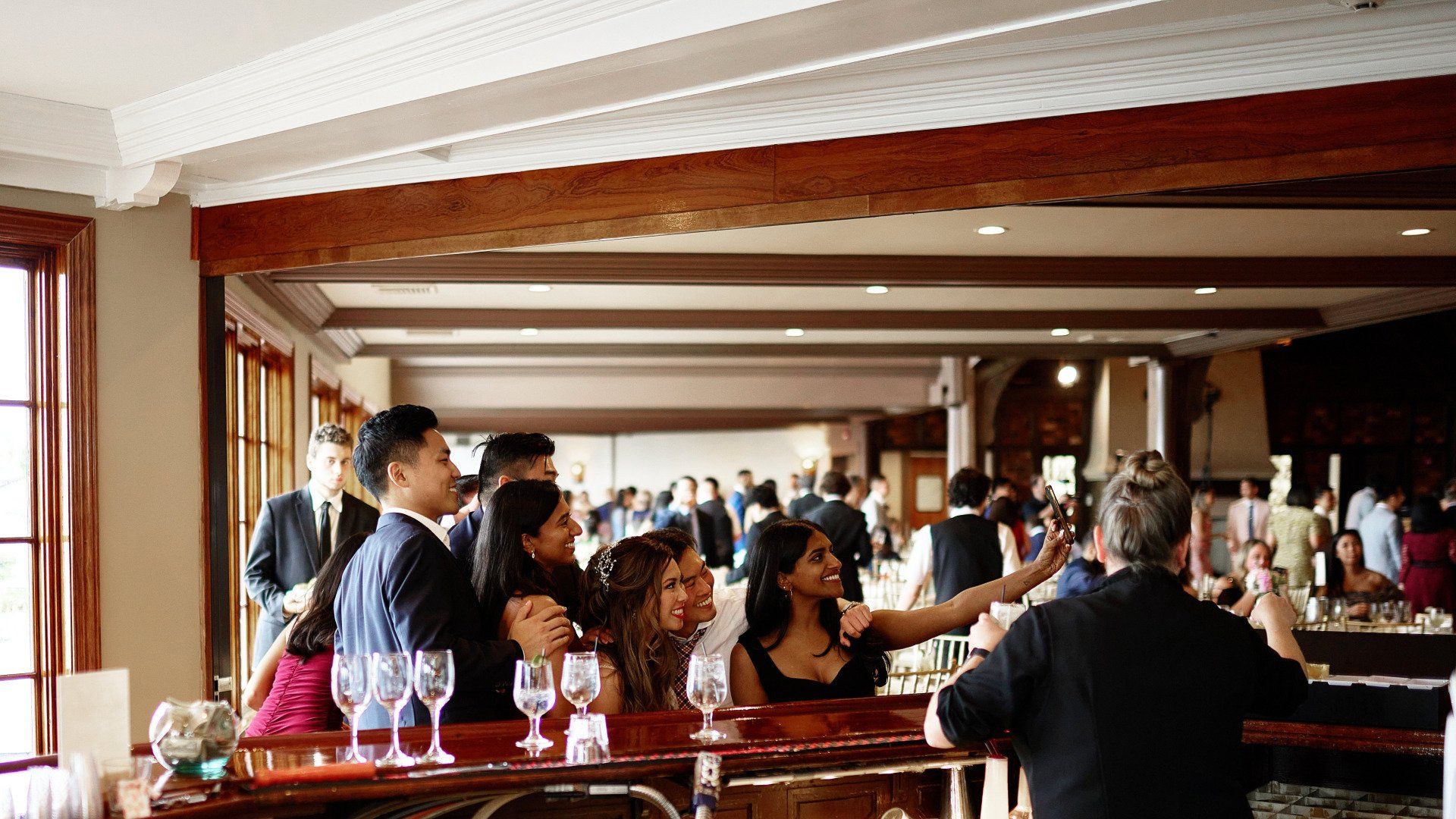 A group of people are sitting at a bar in a restaurant.