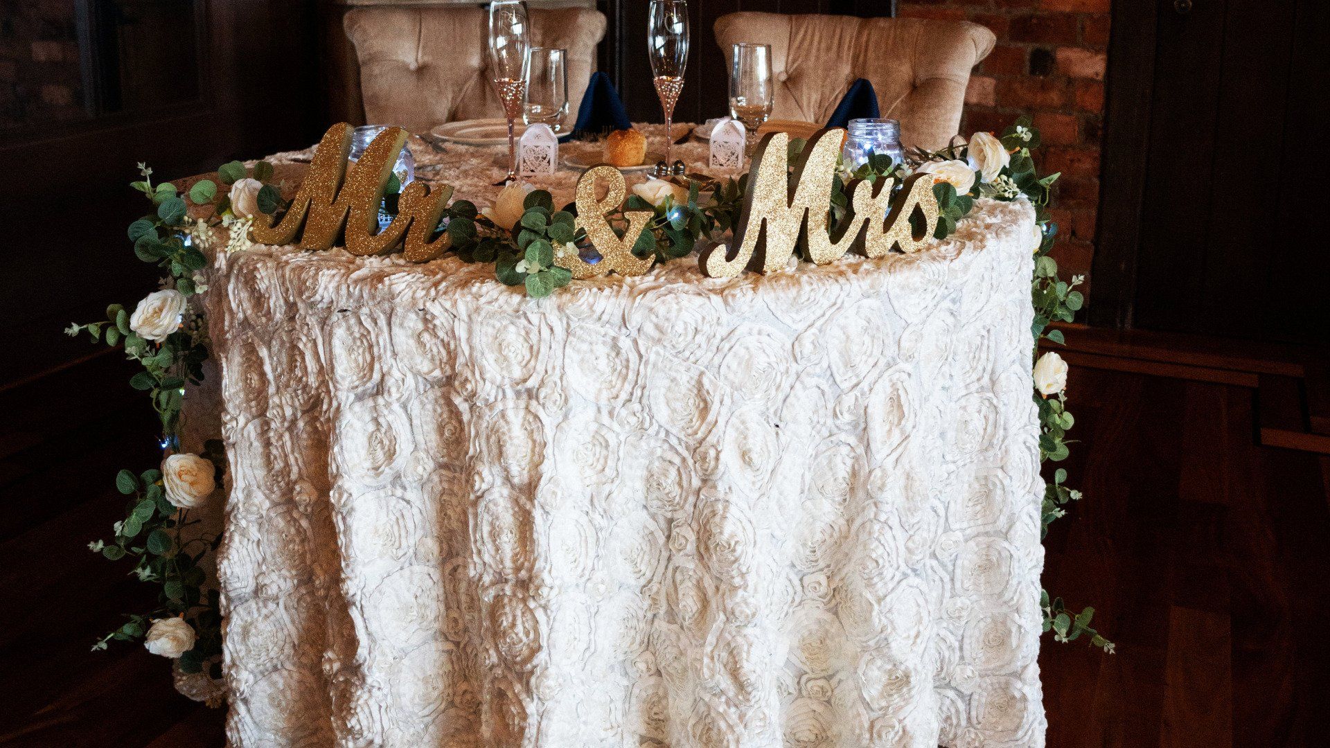 A table with a white tablecloth and a sign that says `` mr. and mrs. ''