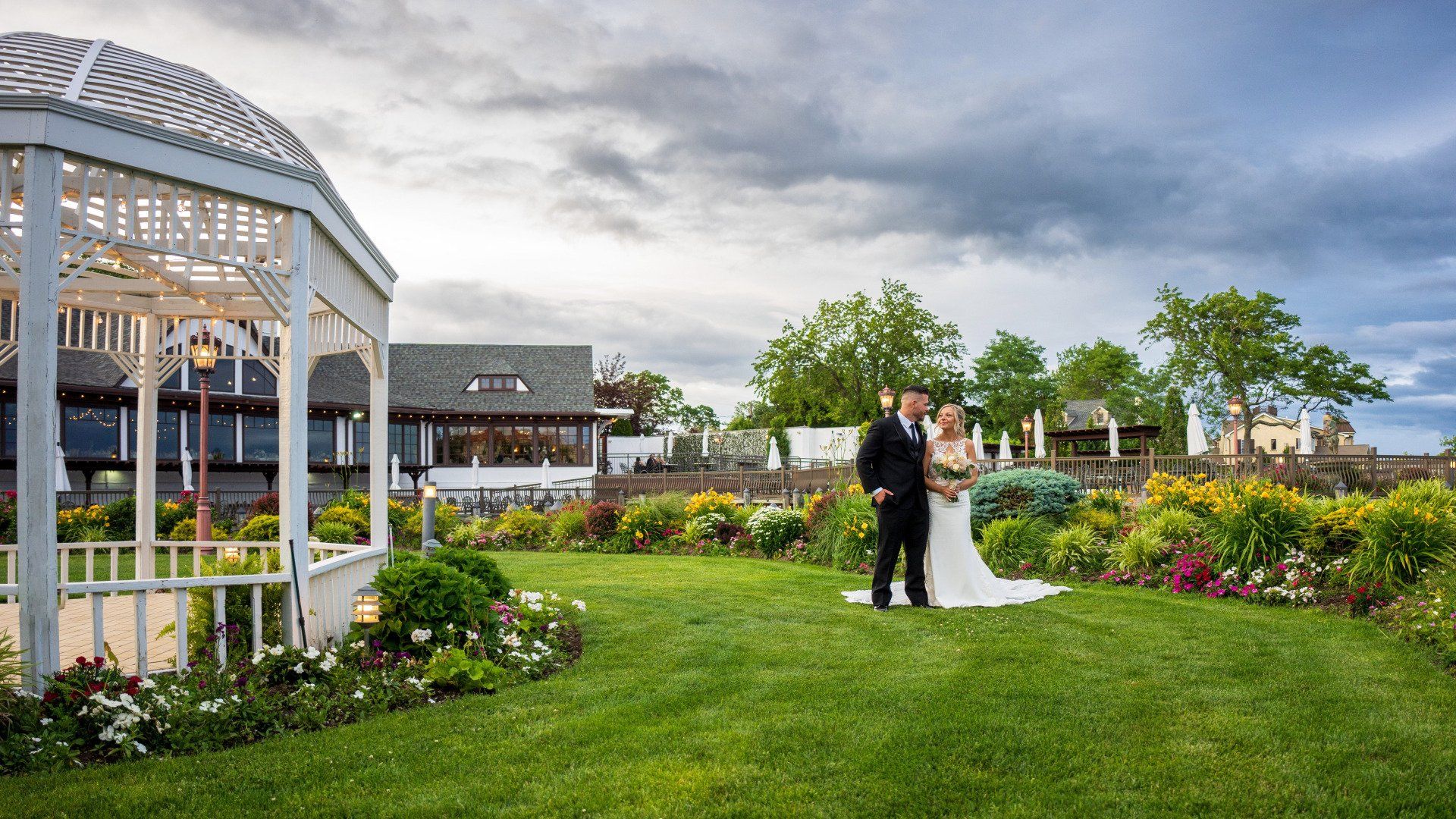 A bride and groom are posing for a picture in front of a gazebo.