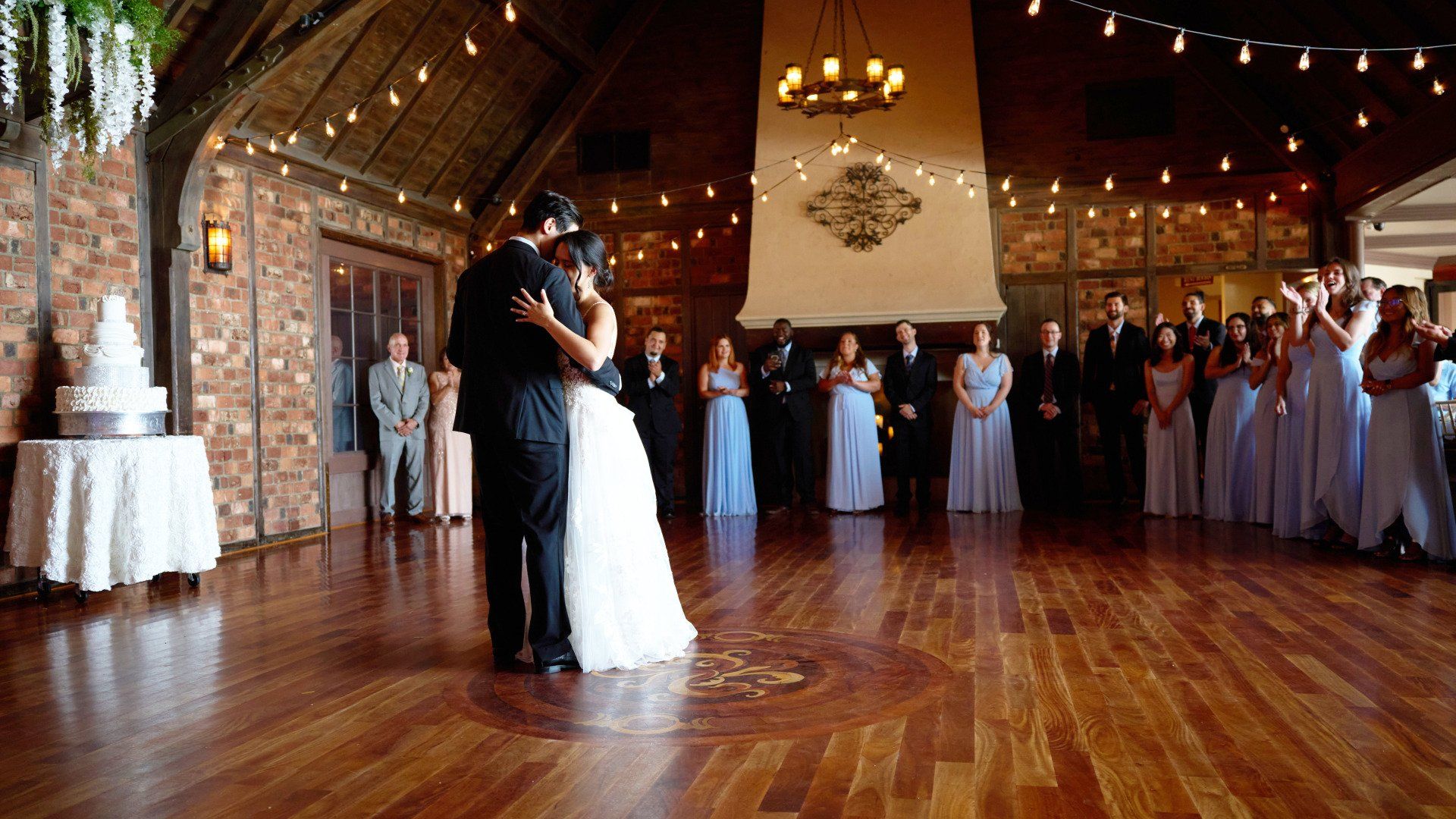 A bride and groom are dancing their first dance at their wedding reception.