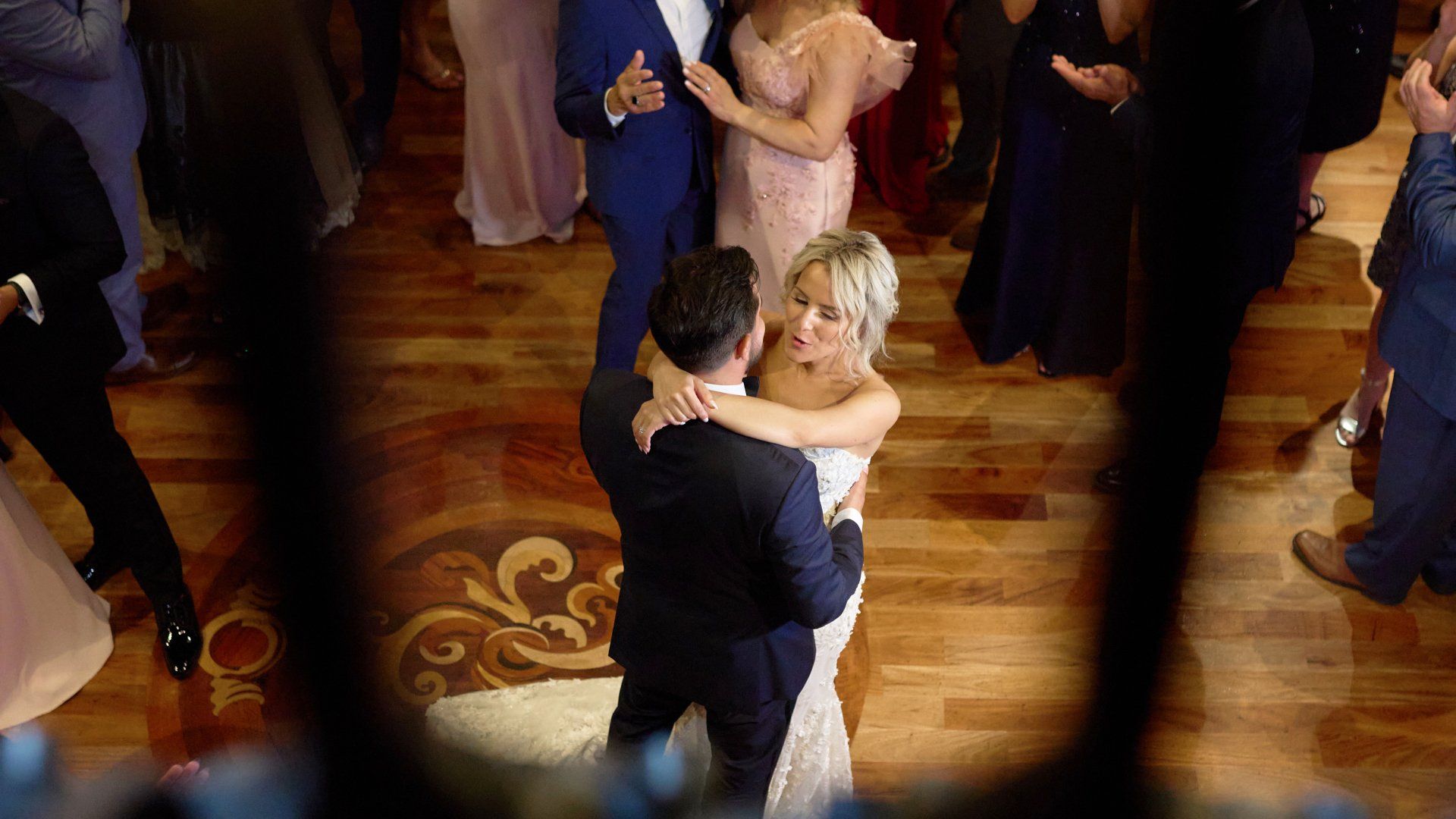 A bride and groom are dancing at their wedding reception.