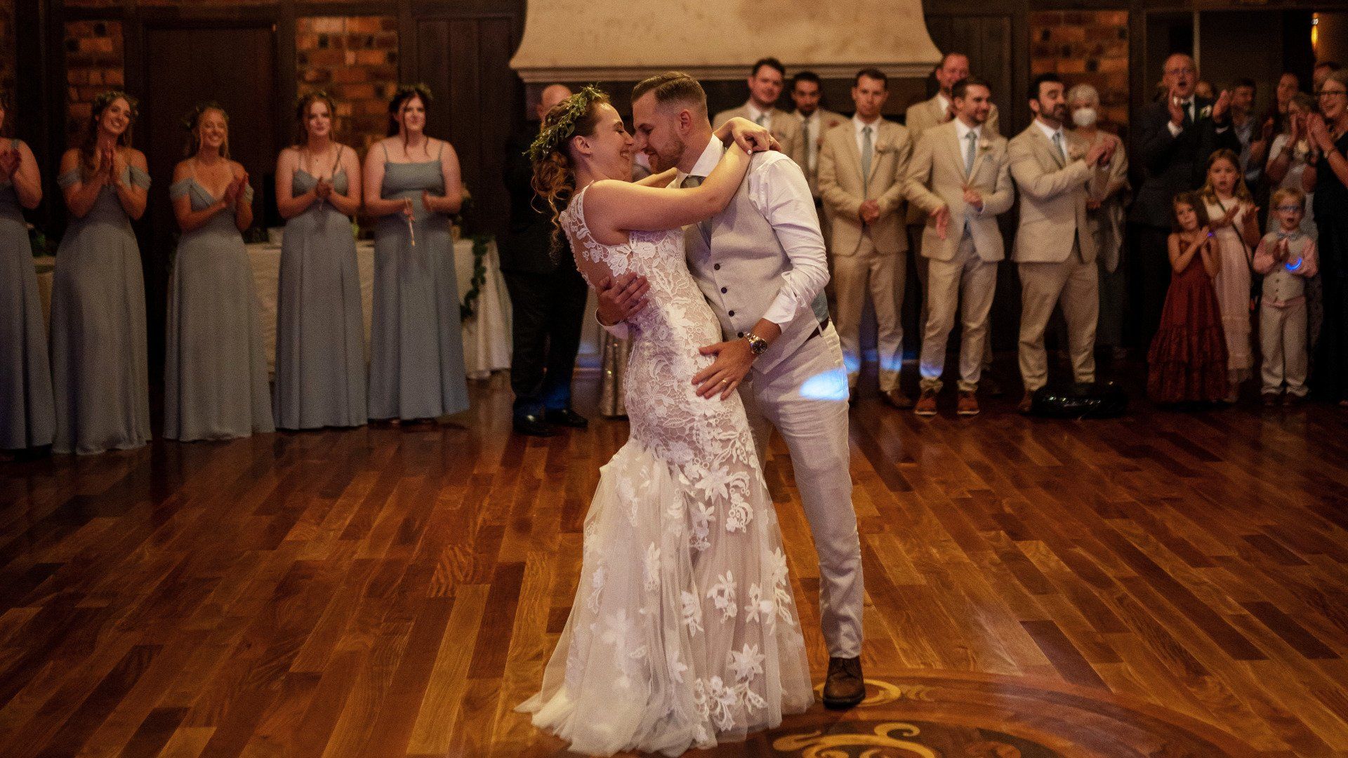 A bride and groom are dancing their first dance at their wedding reception.