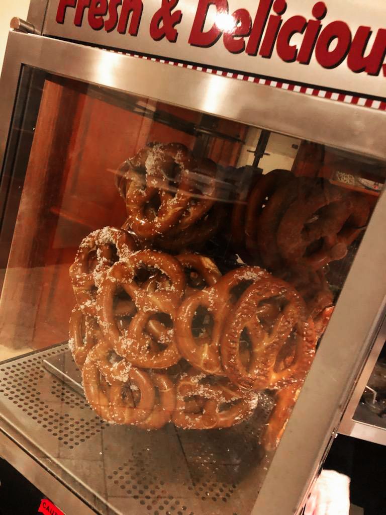 A bunch of pretzels in a display case that says fresh & delicious