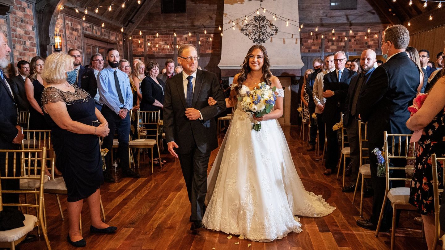 a bride is walking down the aisle with her father at her wedding .