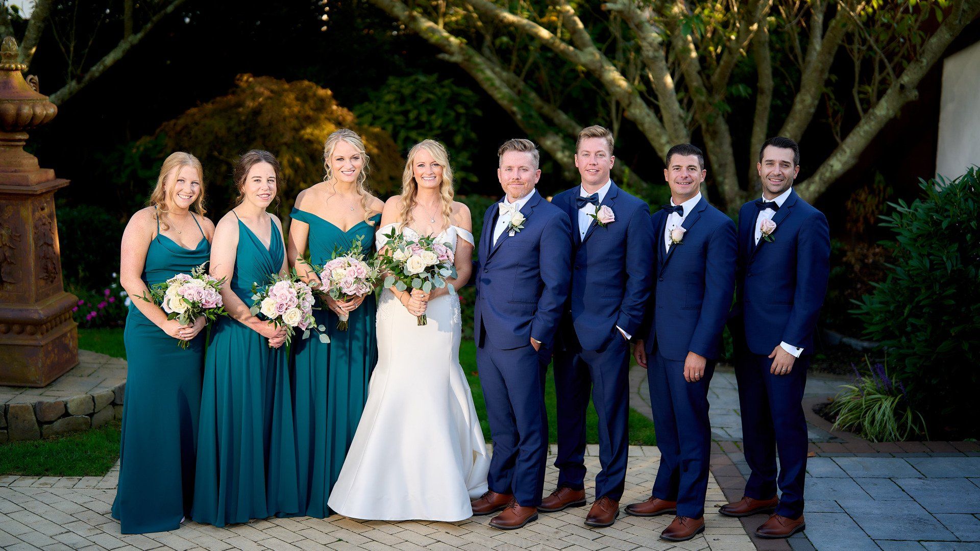 The bride and groom are posing for a picture with their wedding party.