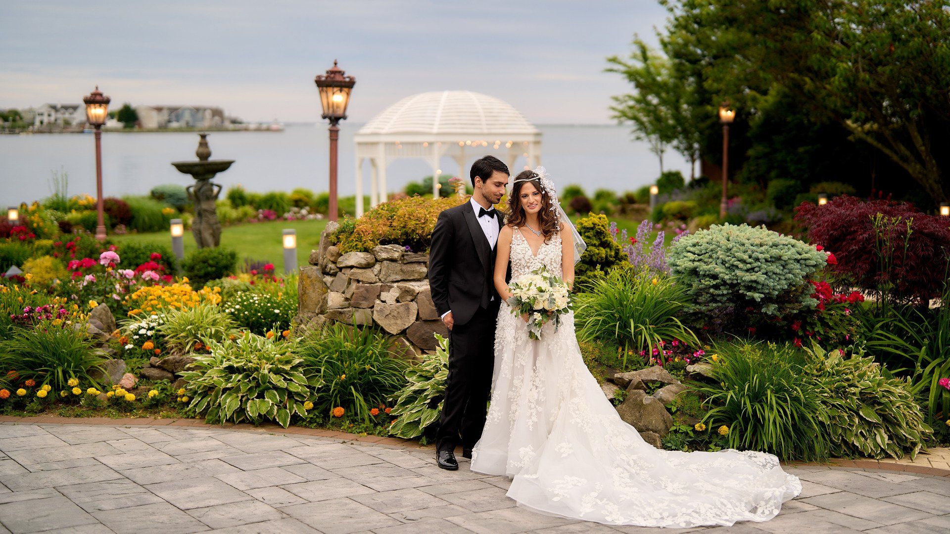 A bride and groom are posing for a picture in front of a gazebo.