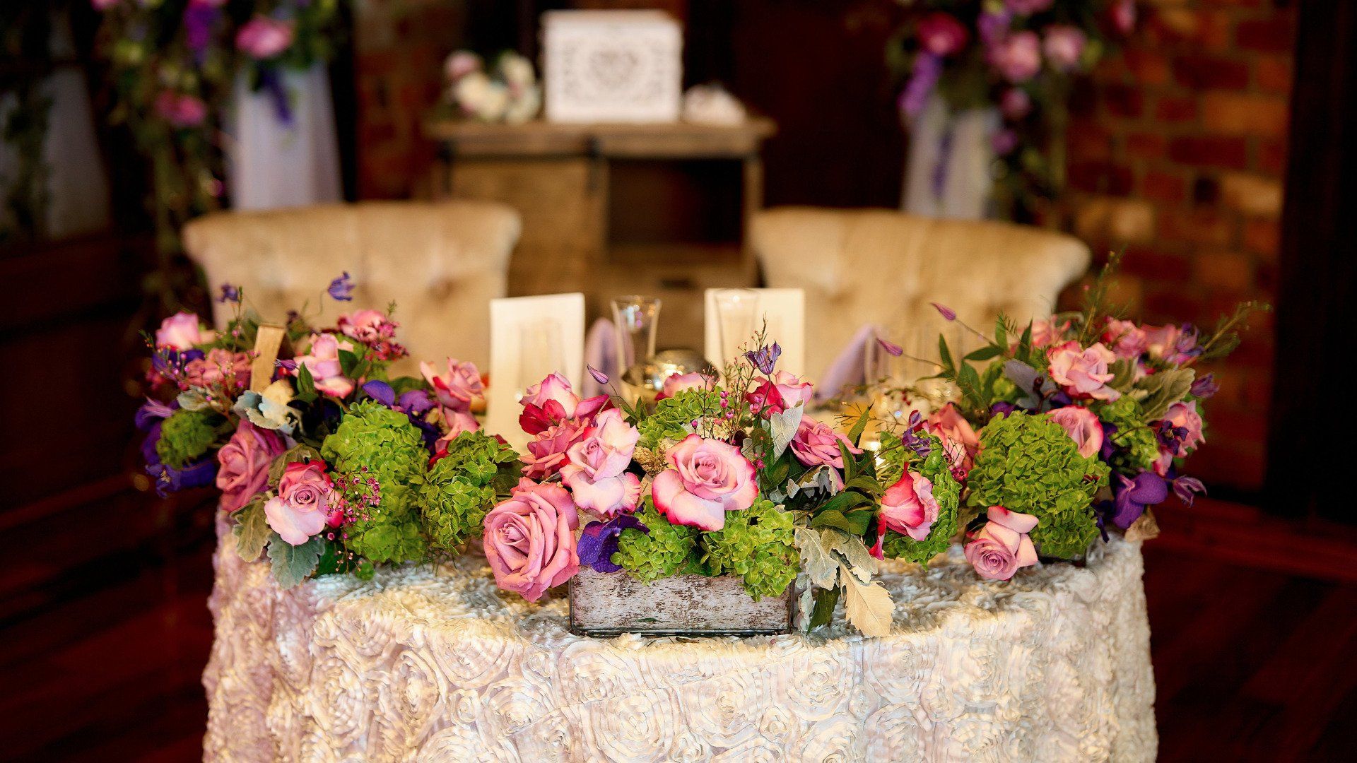 A table with flowers and candles on it in a room.
