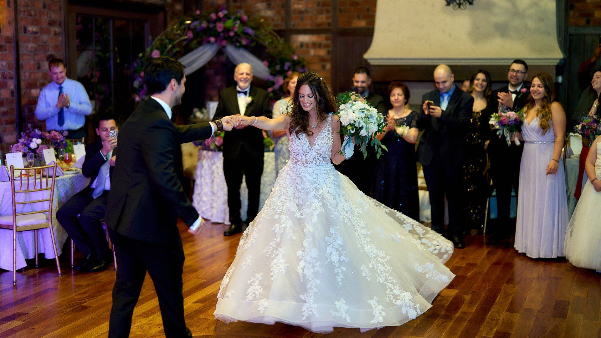 A bride and groom are dancing their first dance at their wedding reception.