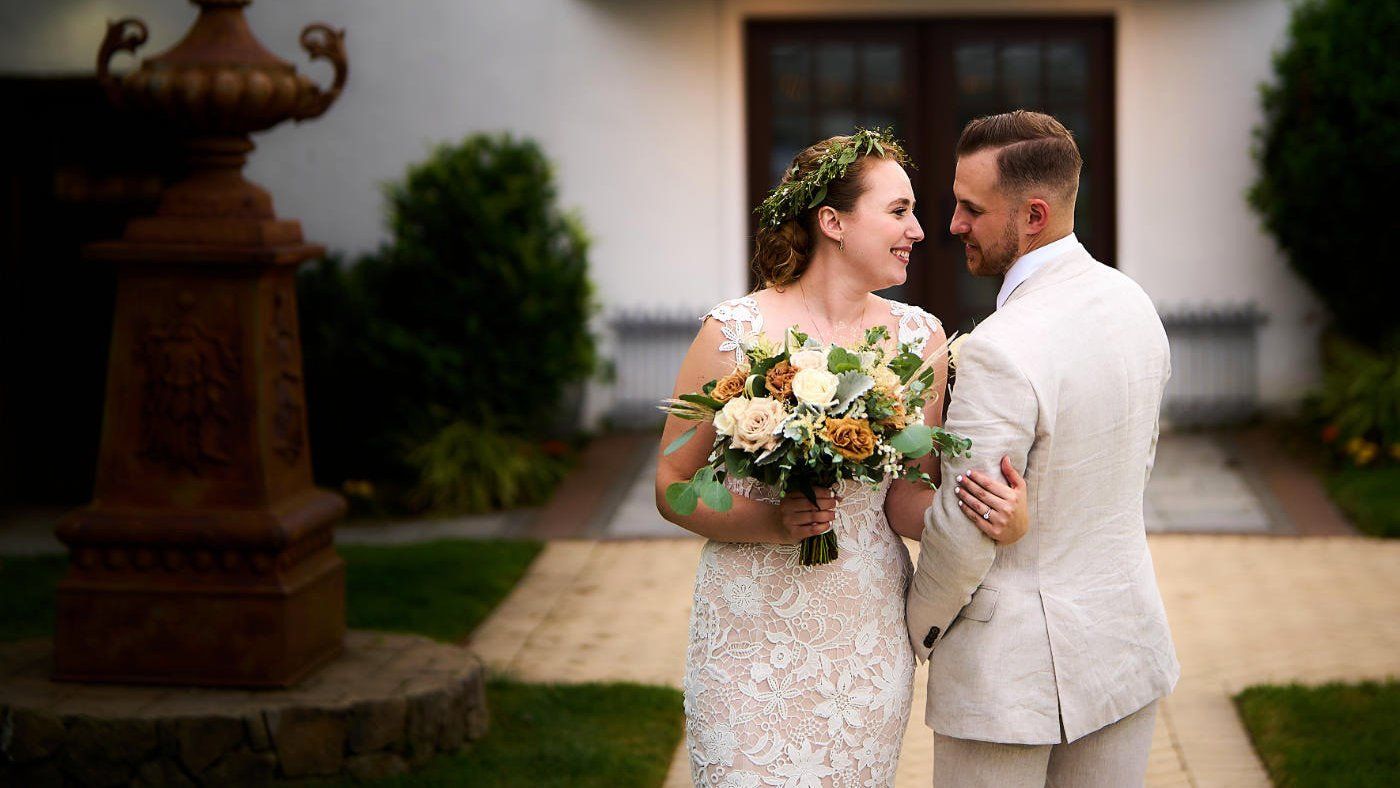 A bride and groom are posing for a picture in front of a building.