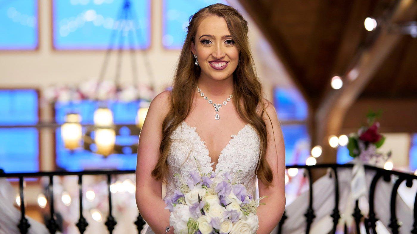 A bride in a wedding dress is holding a bouquet of flowers.