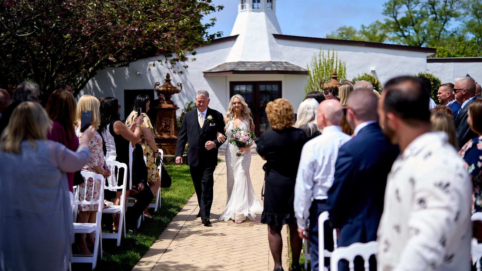 A bride and groom are walking down the aisle at a wedding ceremony.