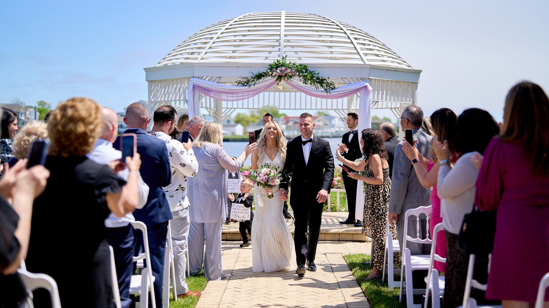 A bride and groom are walking down the aisle at their wedding.