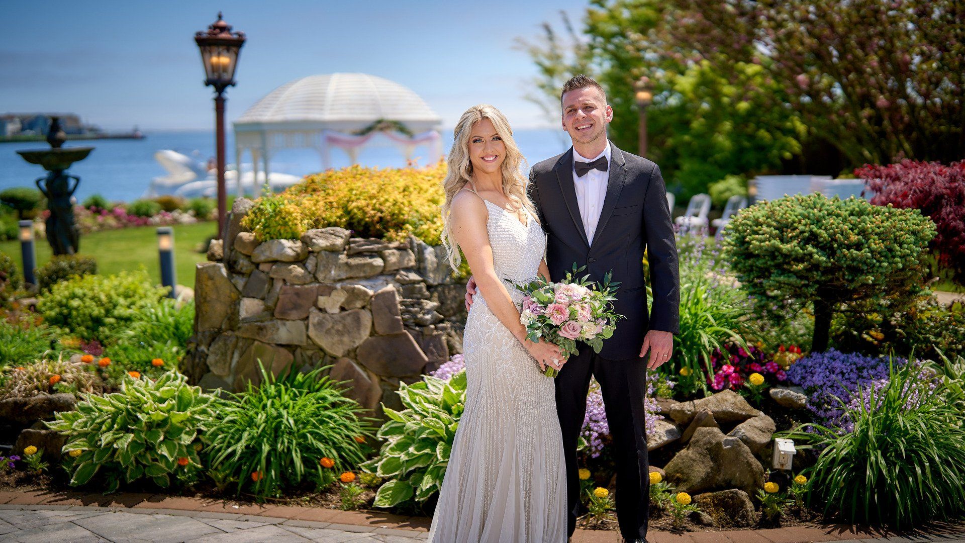 A bride and groom are posing for a picture in a garden.
