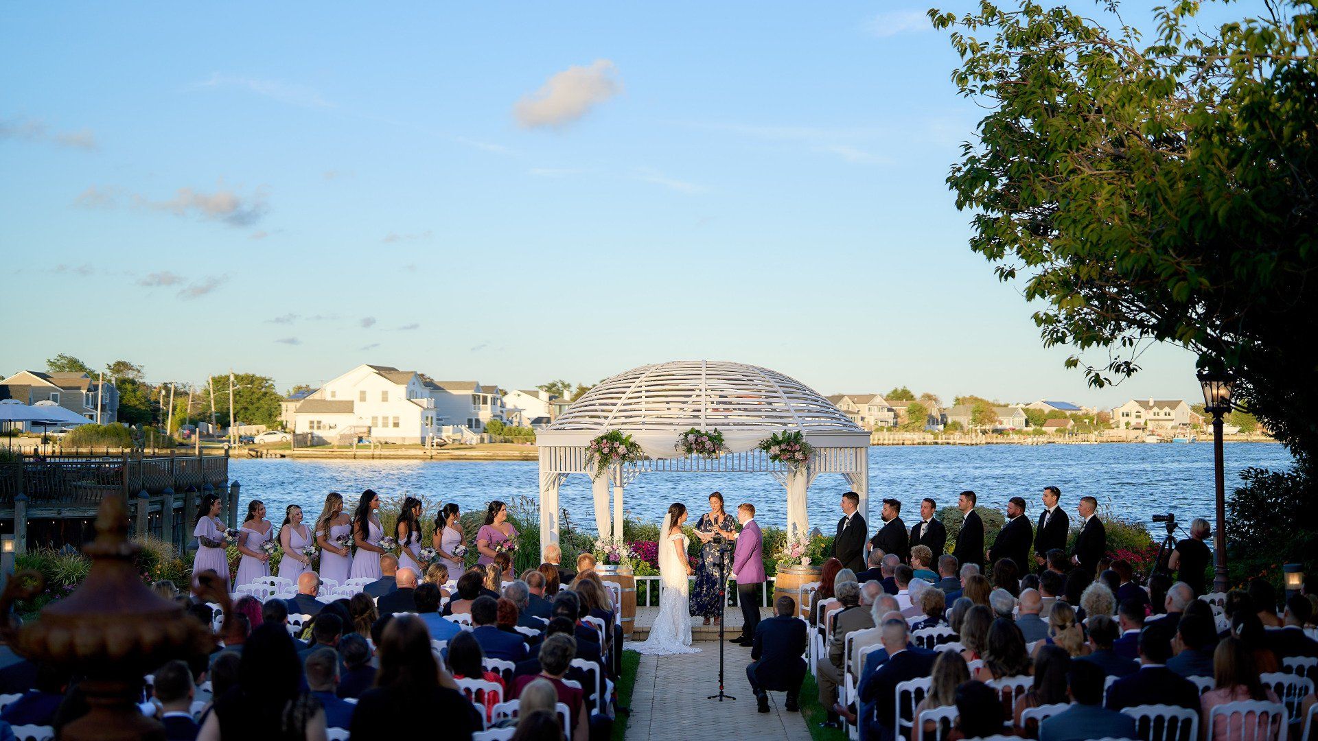 a wedding ceremony is taking place in front of a body of water .