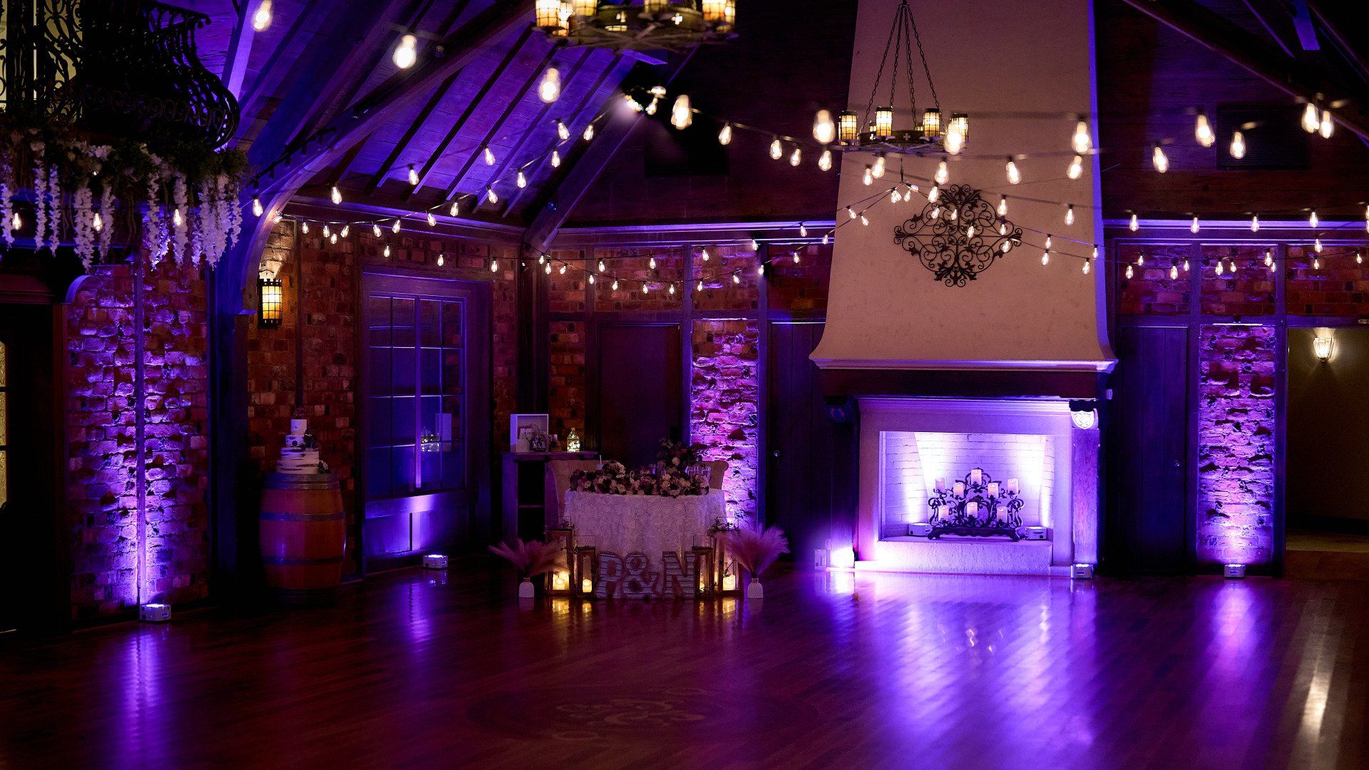 A large room with purple lights and a fireplace.