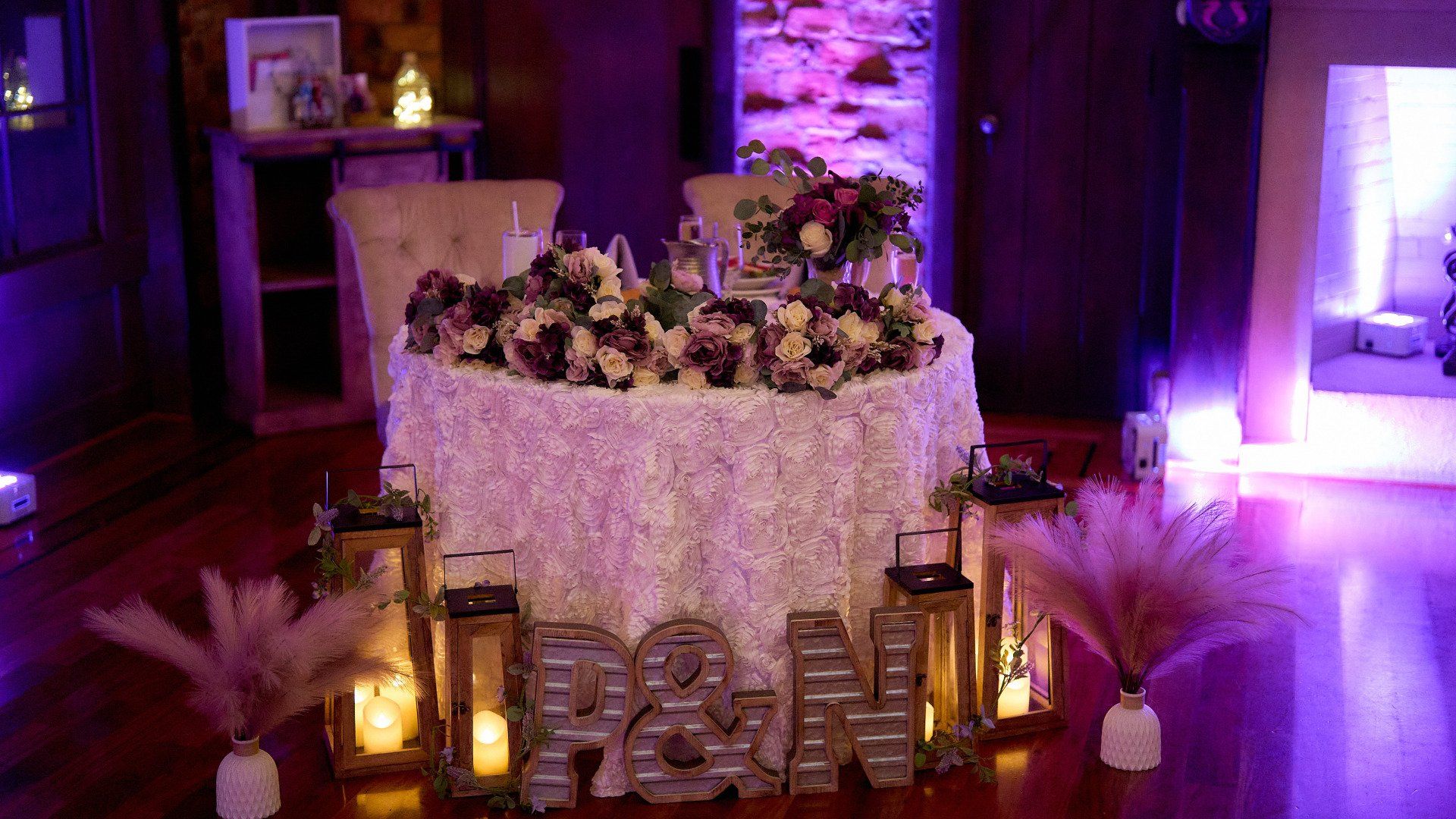 There is a table with flowers and candles on it.